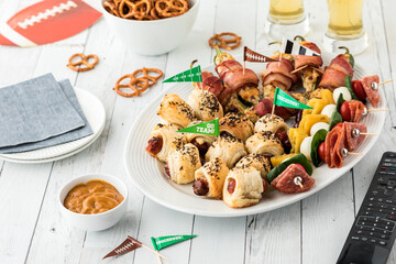 A platter of game day appetizers ready for sharing and served with beer.