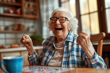 Happy old lady playing bingo at her home kitchen