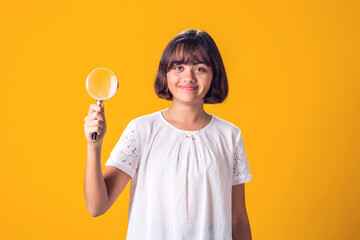 Girl holding magnifier in hand. Education and curiosity concept