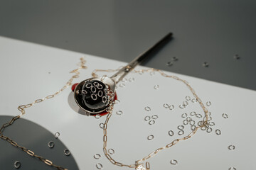 silver spoon holds a good cherry, gold chain draped around, silver jump rings 