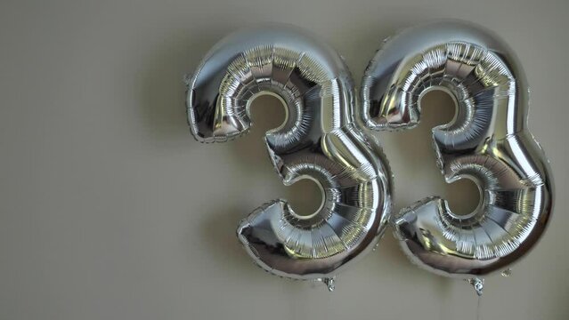 Party Happy Birthday Thirty-Three with Silver Grey number . Gel balls 33 for congratulations celebrations holiday. Close-up, neon lighting, no people