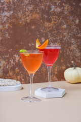 Bright alcoholic cocktails in steamed glasses on podiums or pedestal