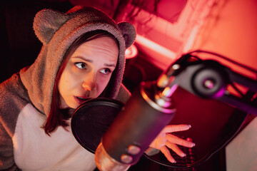 A female announcer is sitting in a room and talking into a microphone