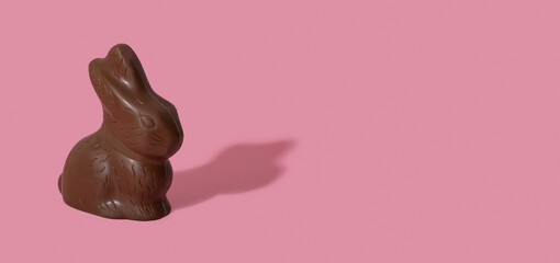 Chocolate rabbit symbol to Easter holidays isolated n a pink banner background with copy space.