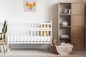 Interior of light bedroom with baby crib and shelving unit - obrazy, fototapety, plakaty