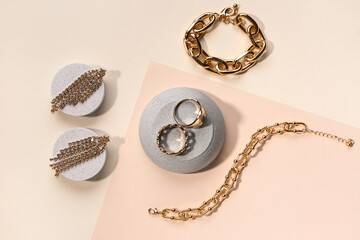 Decorative podiums with beautiful jewellery on color background