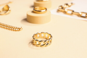 Decorative podiums with golden rings and bracelets on color background