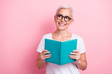 Portrait of toothy beaming person with white hairdo dressed stylish t-shirt read book look at sale empty space isolated on pink background