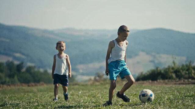 Two Skinny Boys Fall on the Grass Fighting for the Ball, Siblings Rivalry. Concept of Future Athletes, Aspiring Footballers, UEFA EURO, FIFA World Cup