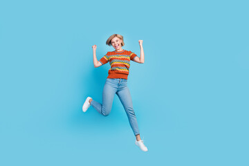 Fototapeta na wymiar Full length photo of crazy ecstatic girl wear strited t-shirt jeans flying scream yeah win lottery isolated on blue color background