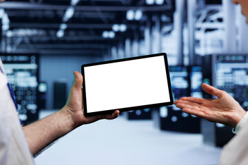 Senior teamworking colleagues in high tech workplace using mock up tablet to set up configuration management tools that enable automatic failover and load balancing, preventing server parts failure