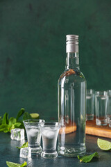 Bottle and glasses of vodka on table