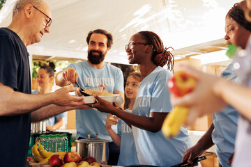 Generous volunteers at food bank, distribute essential items and nourishments to needy. Charity...