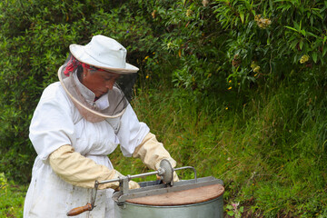 apicultor colocando cuadros con panales de miel en la centrifugadora listo para la extraccion en el...
