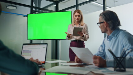 Leader woman presenting mockup project indoors. Lady pointing on greenscreen