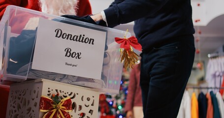 Close up shot of charity box in xmas ornate clothing store. Caring community touched by Christmas...