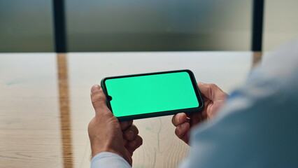 Businessman hands watching chromakey device workplace. Man holding mockup phone