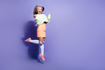 Full body photo of japanese jumping mini girl have fun celebrate victory as fan boyfriend football team isolated on purple color background