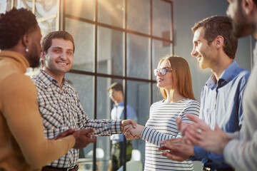 Multiethnic business people shaking hands in office lobby