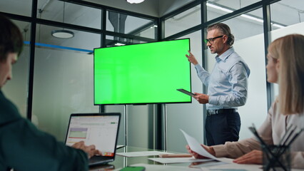 Businessman making chromakey presentation office. Coach pointing at green screen