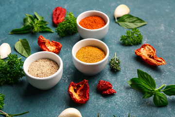 Composition with spices, dried tomatoes and herbs on color background