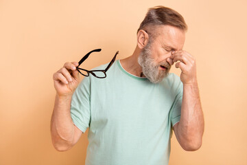Portrait of tired overworked retired man wear stylish t-shirt hold glasses fingers on nose bridge isolated on pastel color background