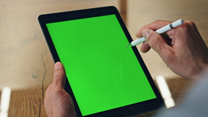 Designer hand drawing greenscreen tablet office closeup. Artist using chroma pad