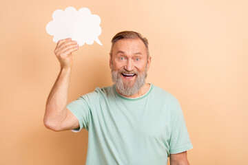 Photo of positive excited senior man wearing stylish clothes announcing news empty space isolated on beige color background