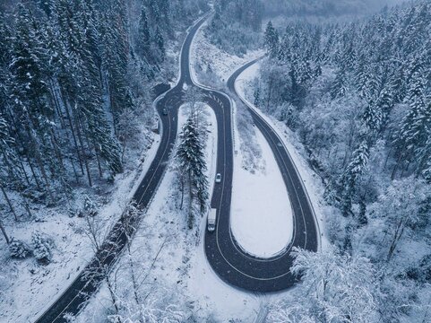 Drone image of a winter roundabout surrounded by snow-covered trees, Calw Hirsau, Black Forest, Germany, Europe