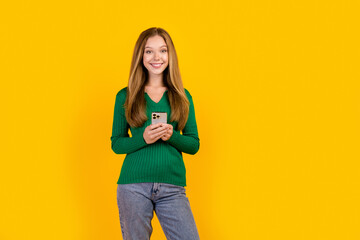 Photo of optimistic young teenage smiling girl wearing green pullover promoting new apple iphone 15...
