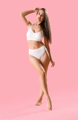 Naklejka premium Beautiful woman in underwear on pink background