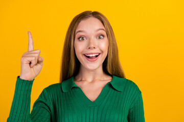 Portrait of funny blonde teenager girl raise finger up she found solution exercise in college eureka isolated on yellow color background