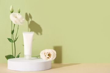 Composition with tube of cosmetic product, plaster podium and beautiful eustoma flowers on color background