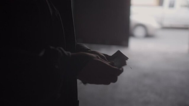 Redheaded woman counting a bundle of bills suspiciously.