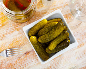 Traditional russian cuisine, preserved salted green cucumbers, served in a cafe