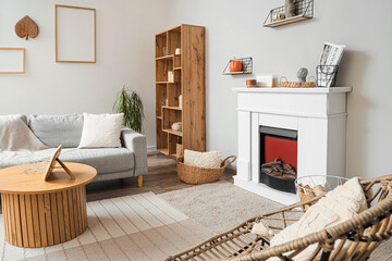 Interior of modern living room with fireplace, grey sofa and chairs