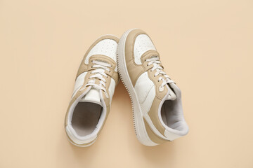 Stylish sneakers on beige background