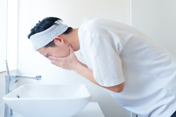 洗面台で洗顔をする男性