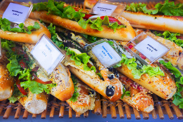 Image of tasty French sandwiches with cheese, tomato and olives on the counter