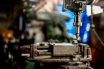 close up metal drill bit stay position for make holes in steel mold. Metal industry. milling process with metal plate parts on CNC milling machine. shop floor milling operation by milling machine.