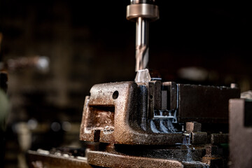 close up metal drill bit stay position for make holes in steel mold. Metal industry. milling process with metal plate parts on CNC milling machine. shop floor milling operation by milling machine.
