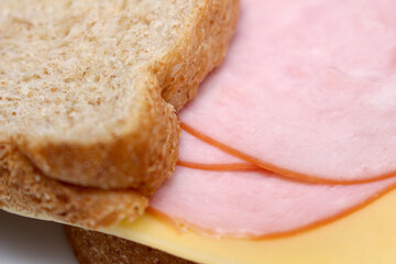 sandwich with cheese and light meat. bread with light meat and cheese. meal details. food texture.