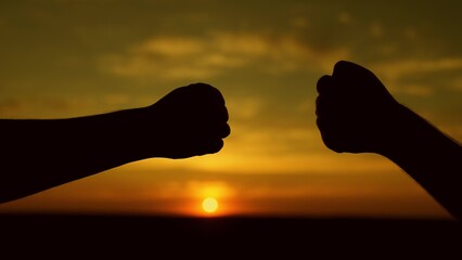 Male fists against the sky, trust, harmony, friendship. Teamwork concept. Fist to fist - a sign,...