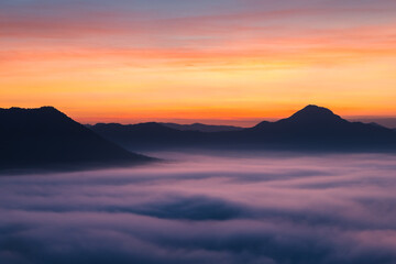 Thick fog covered the mountainside in the morning, with the beautiful twilight light. Landscape aerial view of Phu Thok, Chiang Khan, Thailand