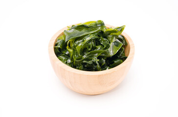 Fresh seaweed wakame in woodle bowl isolated on white background. Copy space. Japanese food