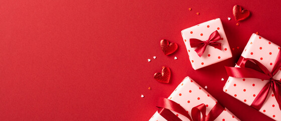 Valentine's day banner template. Flat lay gift boxes with hearts on red background. Top view, copy space. - obrazy, fototapety, plakaty