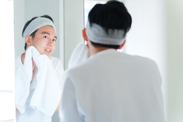 タオルで顔を拭く男性