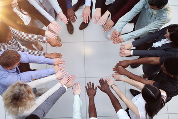 Business people stretched out their hands towards each other while standing in a modern office....