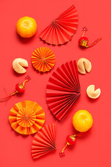 Fortune cookies with mandarins and Chinese symbols on red background. New Year celebration