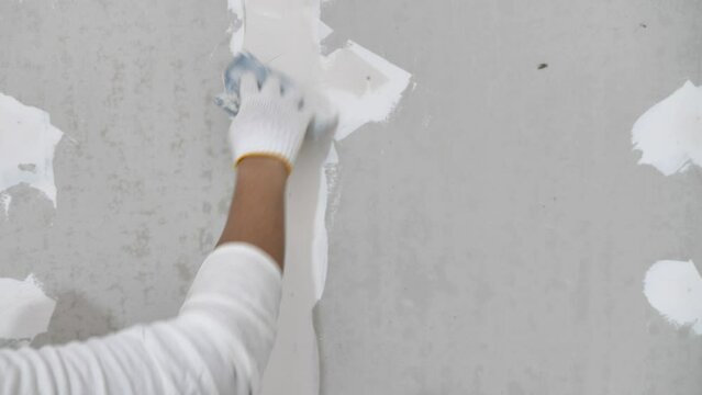 Plasterwork and wall painting preparation. close up hand of craftsman applying filling drywall patch.